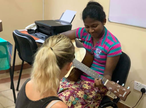 Maria teaching Bhagya guitar